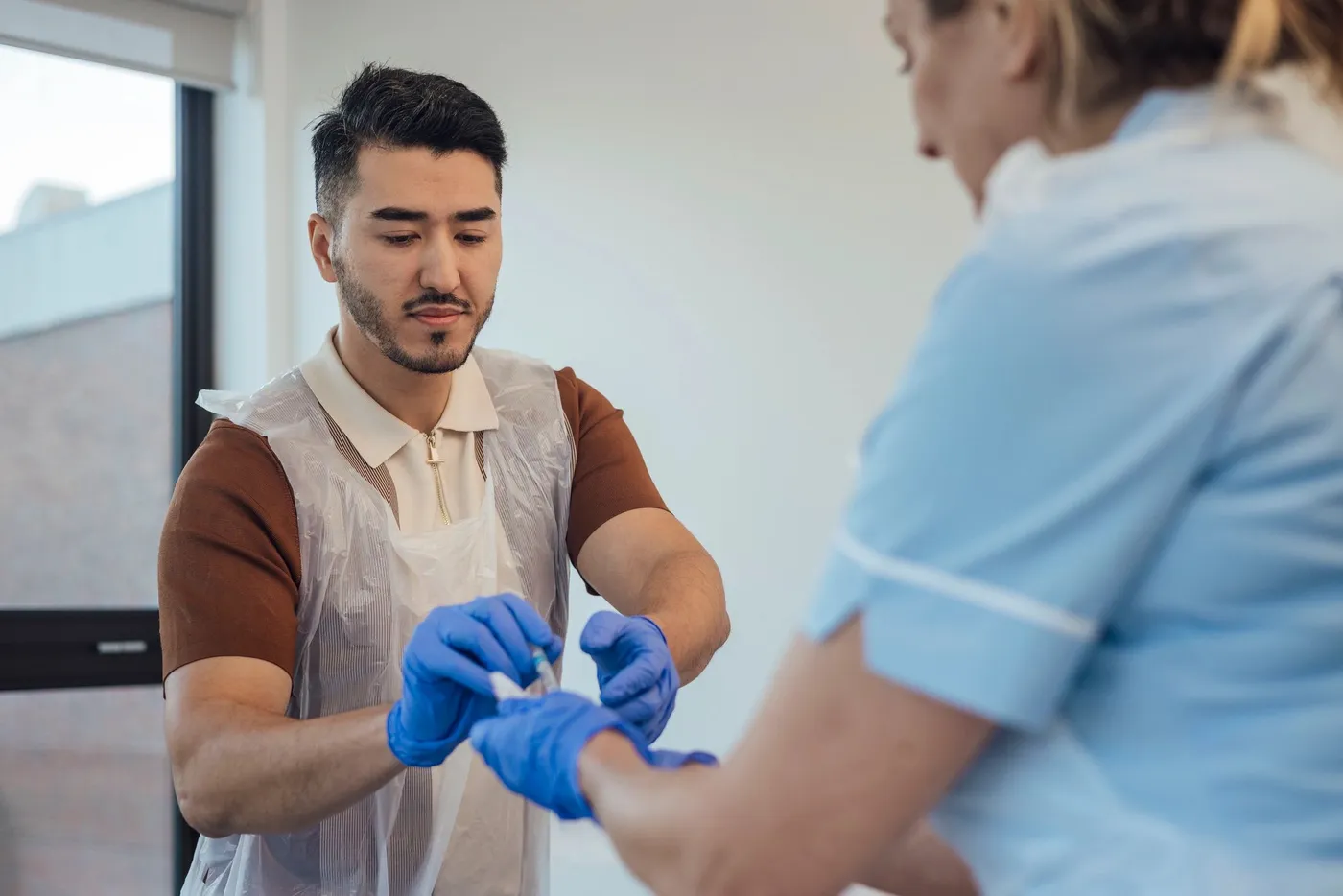 A Direct 2 U Lab professional preparing a patient's arm for a blood draw
