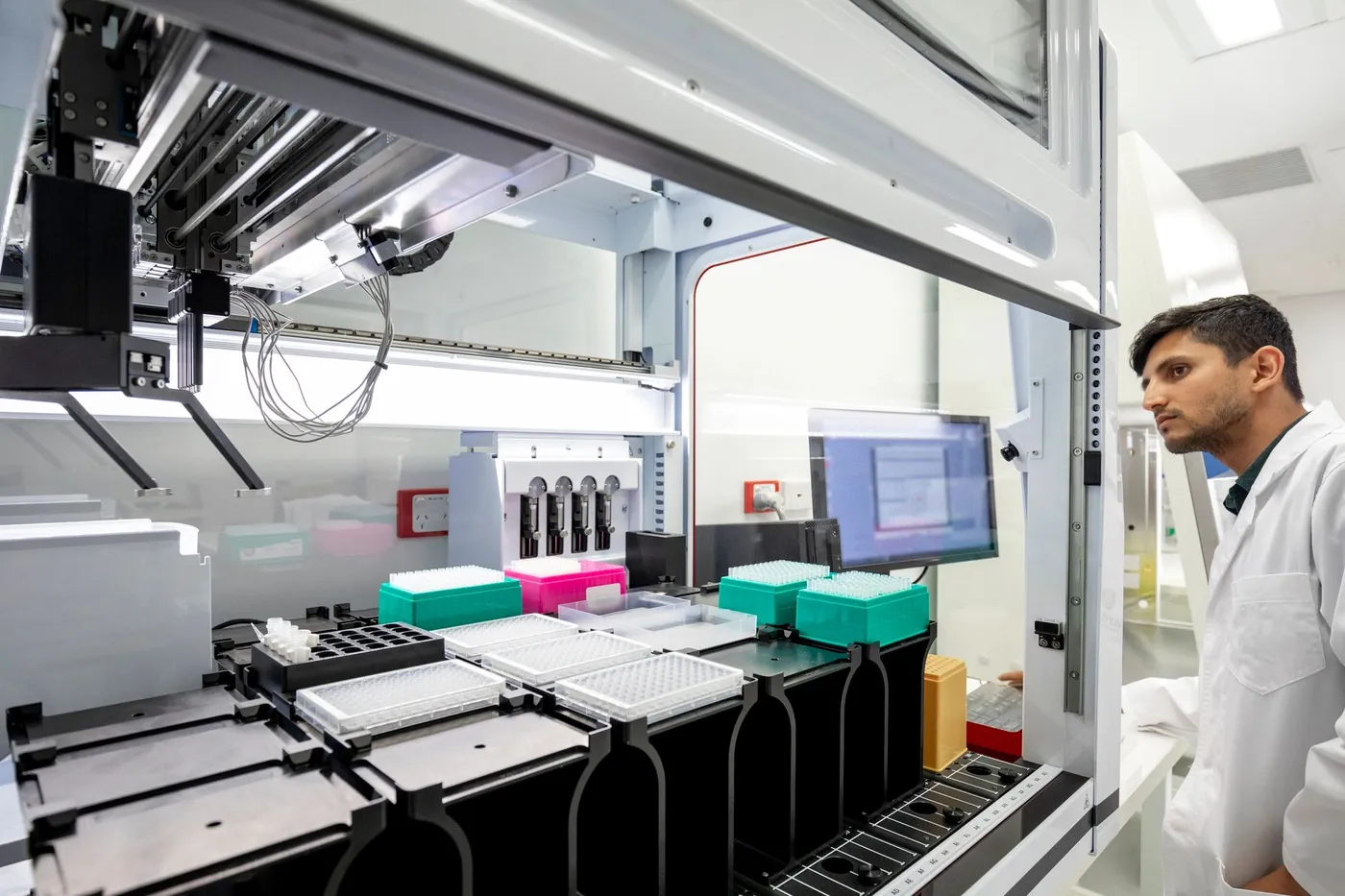 A laboratory scientist working with automated testing equipment